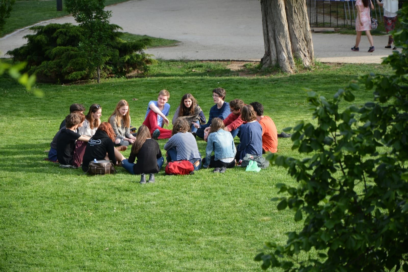 A small group sitting in a circle on the grass