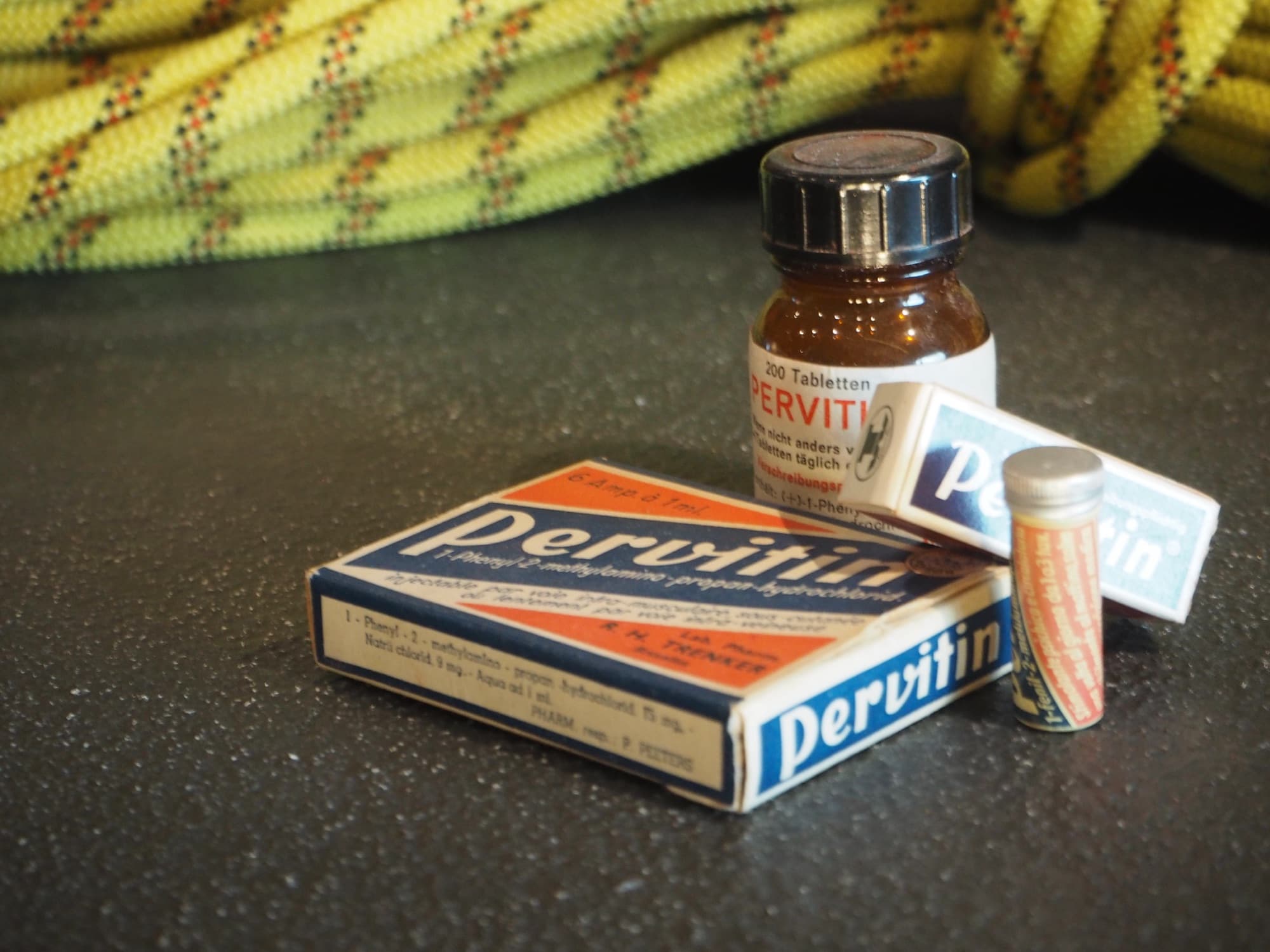 Wartime Pervitin packaging in a museum display: a tablet bottle, two branded boxes, and an ampoule tube of methamphetamine
