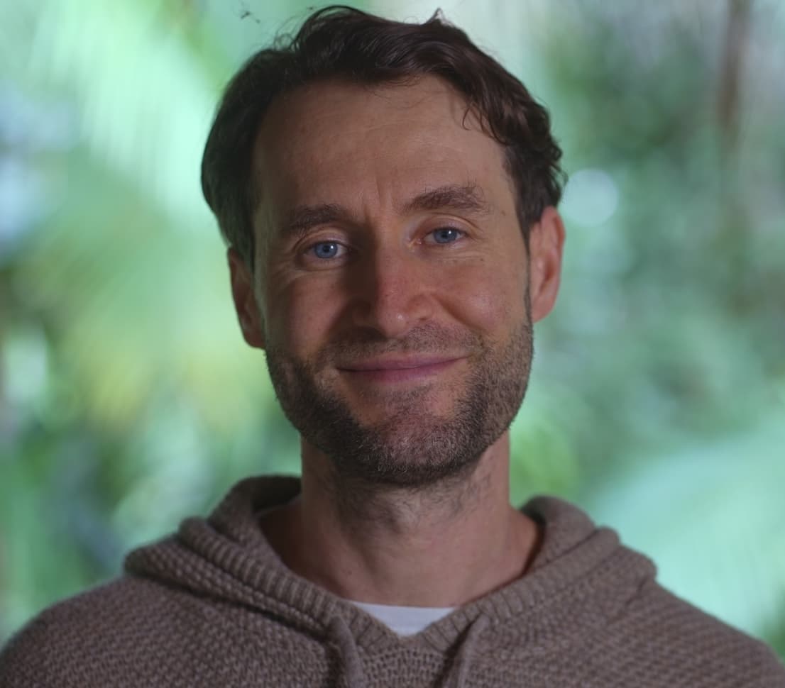 Portrait of Charles Johnston, co-founder of Nekawa, against a green forest background
