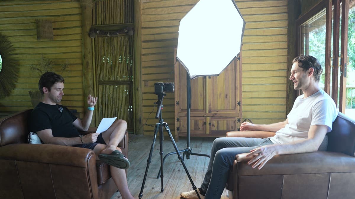 Charles D. Johnston and DJ seated in leather chairs in a wooden room in Paraty, Brazil, during the interview